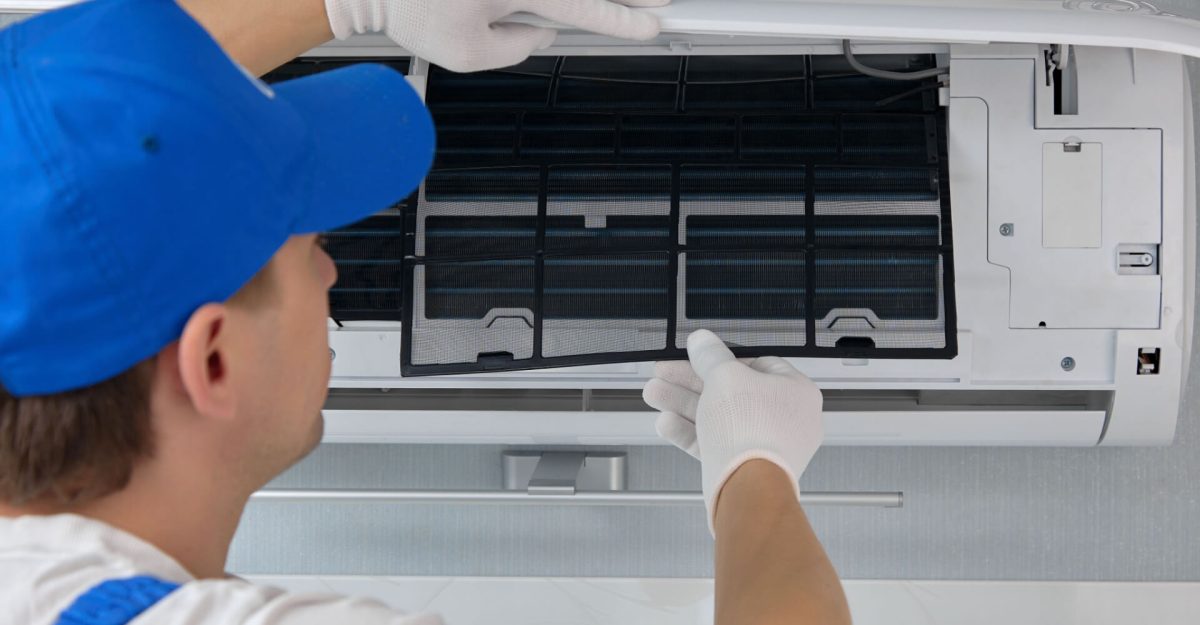 Professional repairman of air conditioning equipment replaces the filter elements