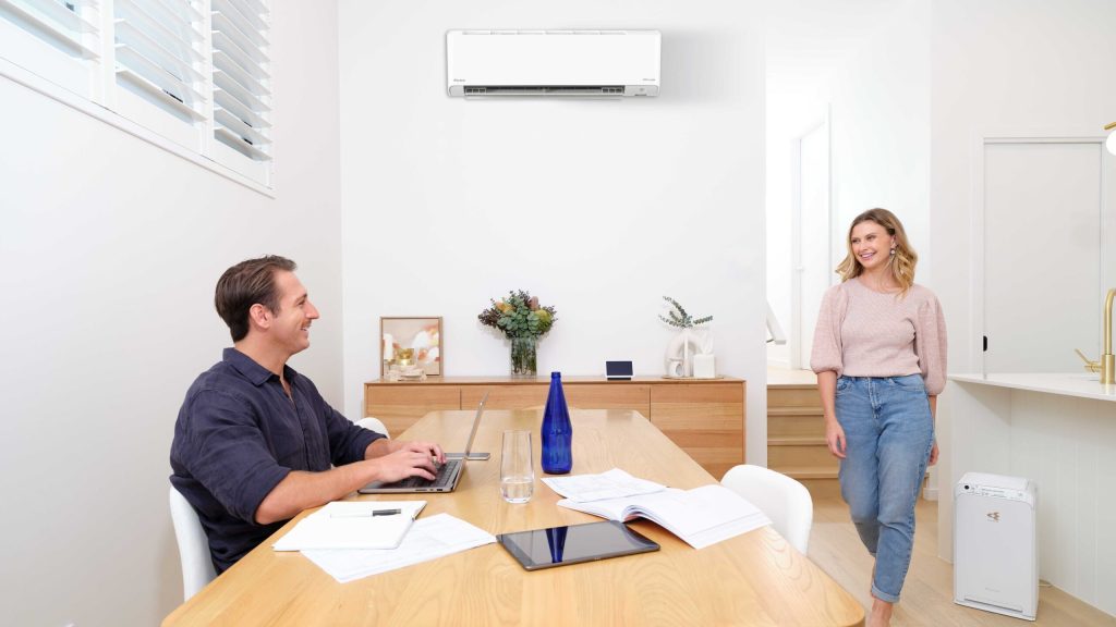Couple meeting with consultant at a table under a split system.